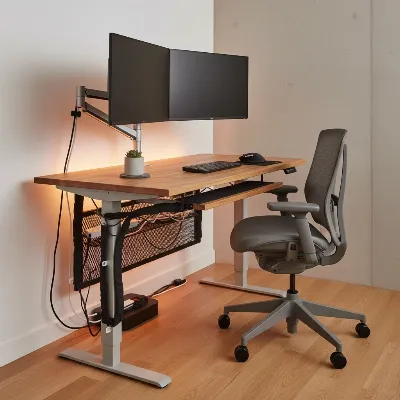 A professional standing desk setup with neatly hidden cables and organized peripherals.